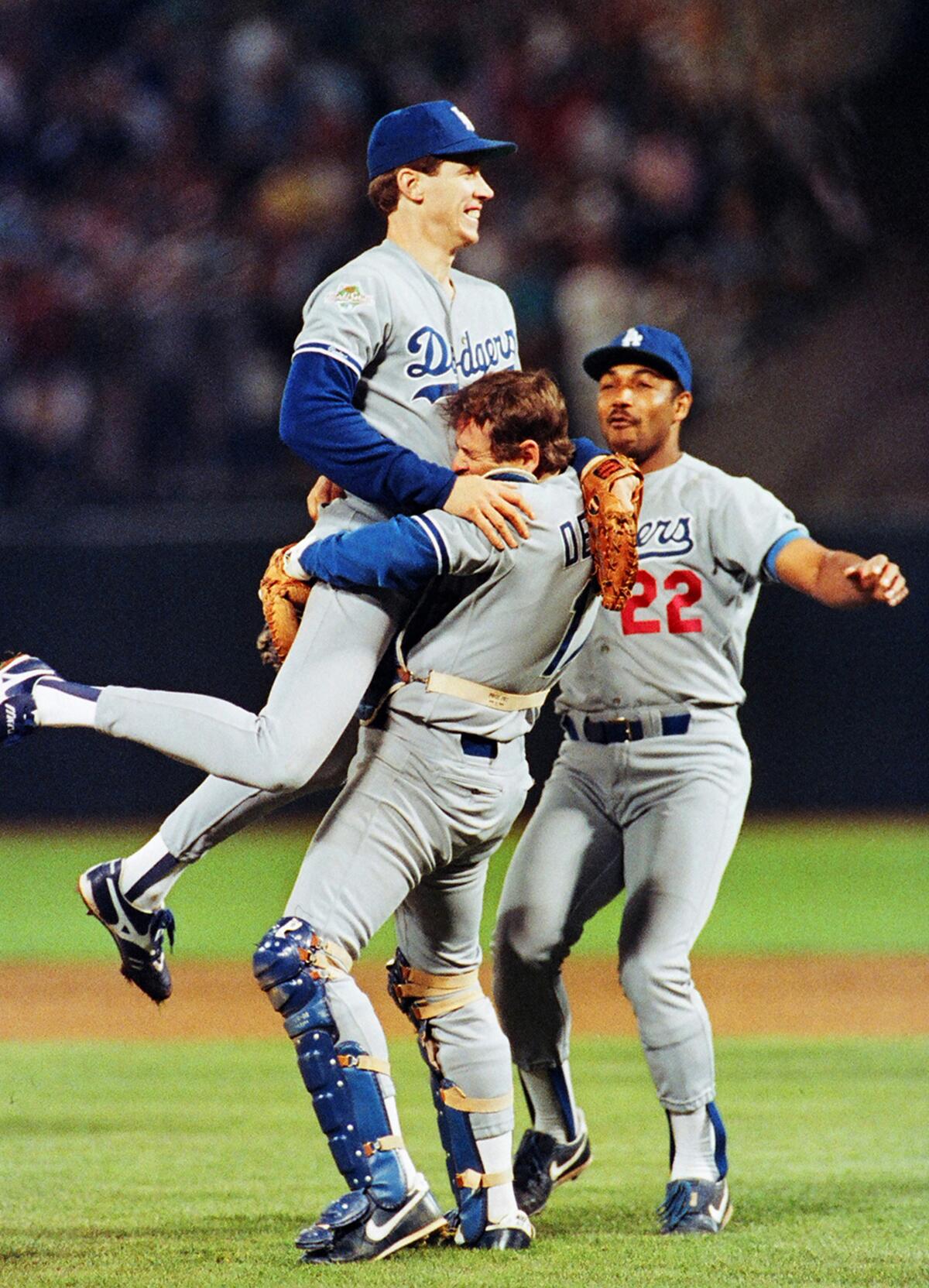 Dodgers starting pitcher Orel Hershiser leaps into the arms of catcher Rick Dempsey to celebrate title.