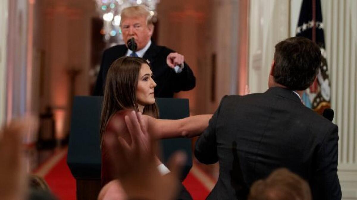 President Trump points an accusatory finger as a White House intern tries to take a microphone away from CNN journalist Jim Acosta during a news conference on Wednesday.
