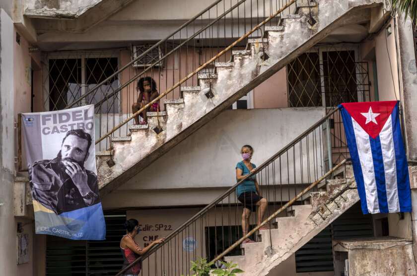 People wait to be vaccinated with the Cuban Abdala vaccine for COVID-19 at a doctors' office, decorated with an image of Fidel Castro and a Cuban flag, in the Alamar neighborhood of Havana, Cuba, Friday, May 14, 2021. Cuba began immunizing people this week with its own vaccines, Abdala and Soberana 02, the only ones developed by a Latin American country. (AP Photo/Ramon Espinosa)