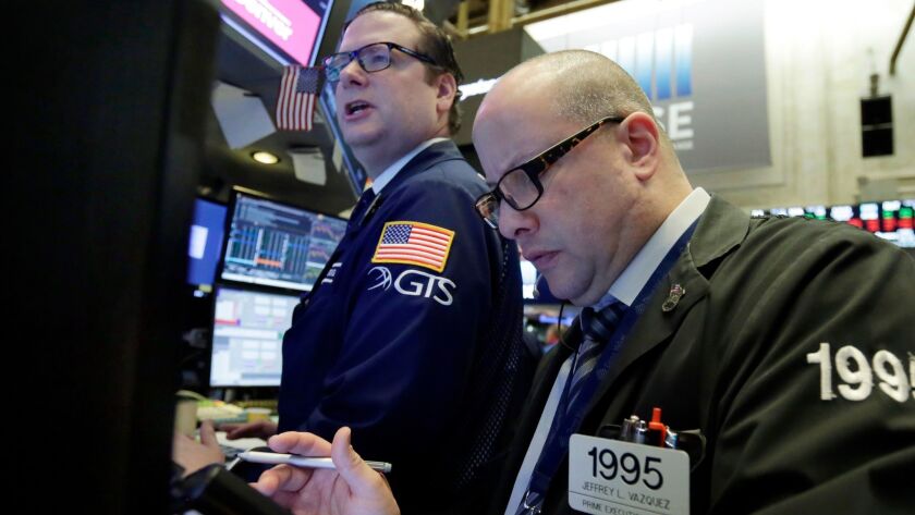 Specialist Gregg Maloney, left, and trader Jeffrey Vazquez work on the floor of the New York Stock Exchange.