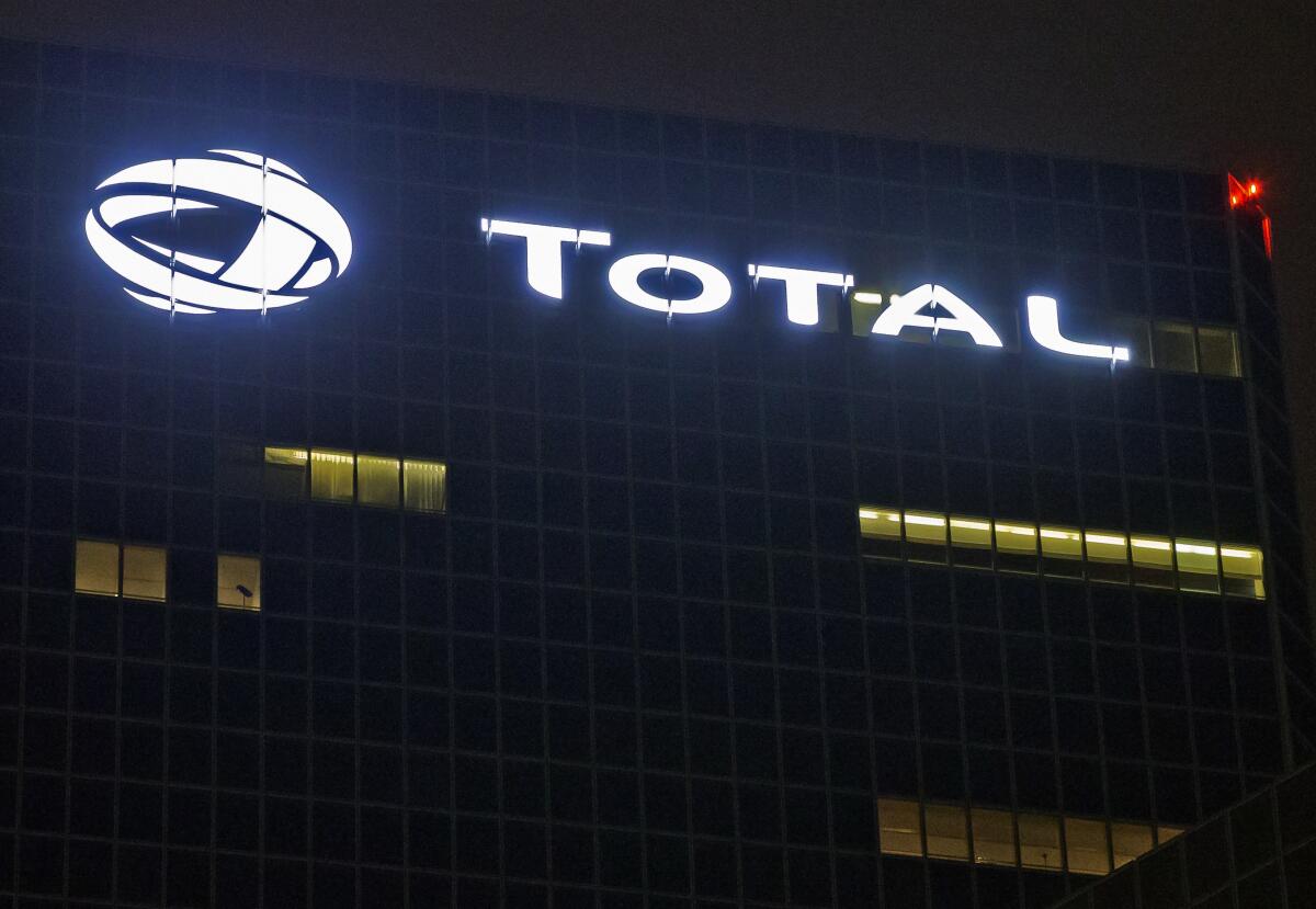 FILE - In this Oct. 12, 2016, file photo, the logo of French oil giant Total SA is pictured at company headquarters in La Defense business district, outside Paris. French energy giant Total signed mega contracts with Iraq worth $27 billion to develop oil fields, natural gas and a crucial water project that officials said Monday, Sept. 6, 2021, will be key for the oil-rich country to maintain crude output. (AP Photo/Michel Euler, File)