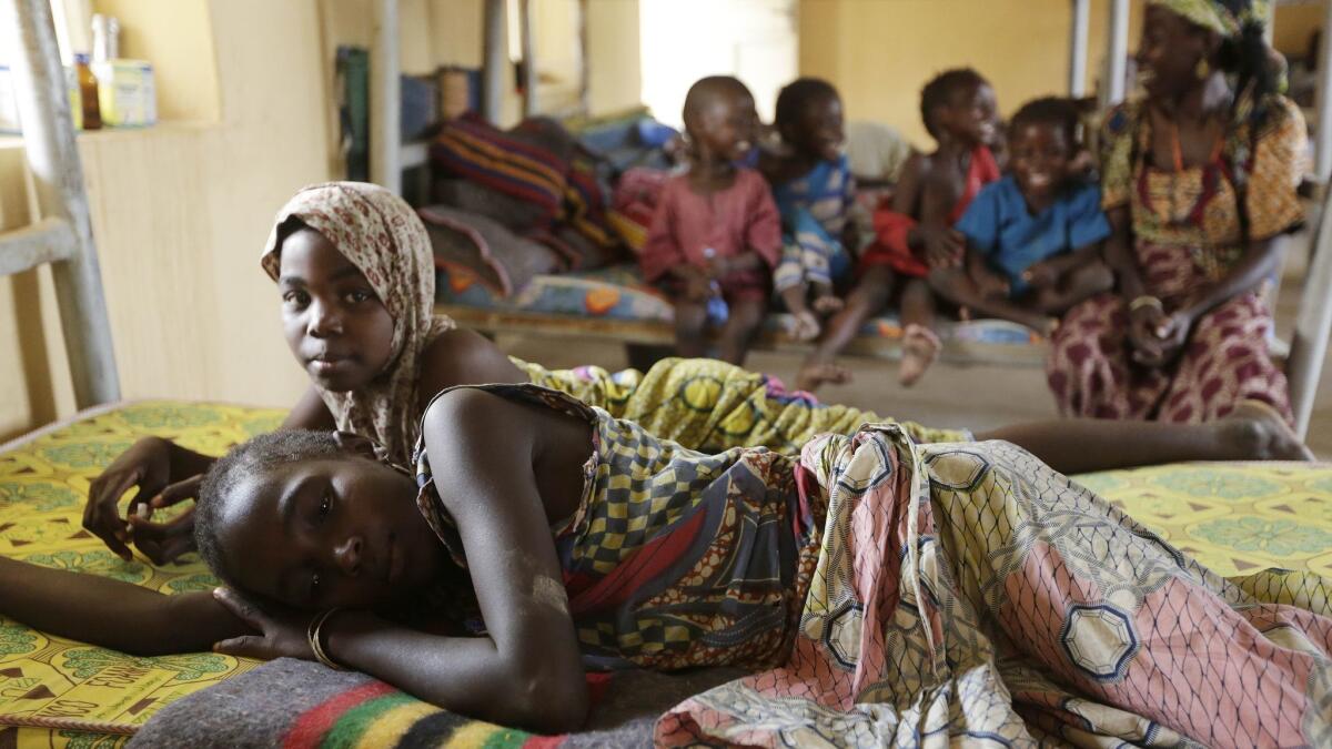 Woman and children rescued by Nigerian soldiers rest at a refugee camp in Yola, Nigeria.