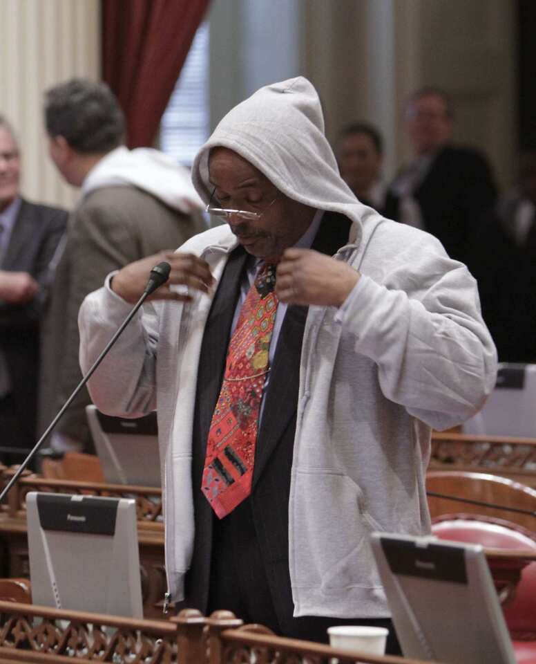 State Sen. Roderick Wright (D-Inglewood) puts on a hooded sweat shirt before speaking in memory of Trayvon Martin at the Capitol in Sacramento.