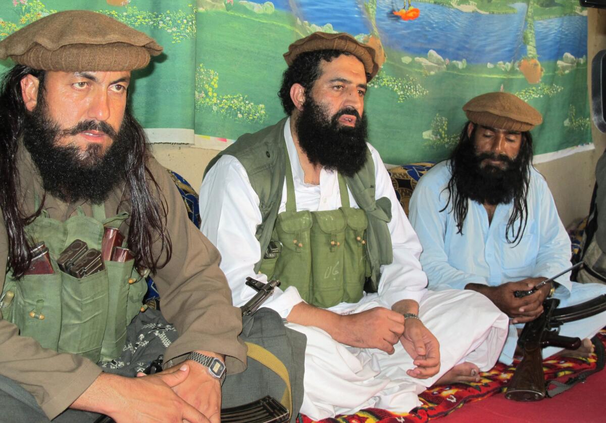 Pakistani Taliban spokesman Shahidullah Shahid, center, flanked by bodyguards, talks to reporters at an undisclosed location in the tribal area of Waziristan last year.