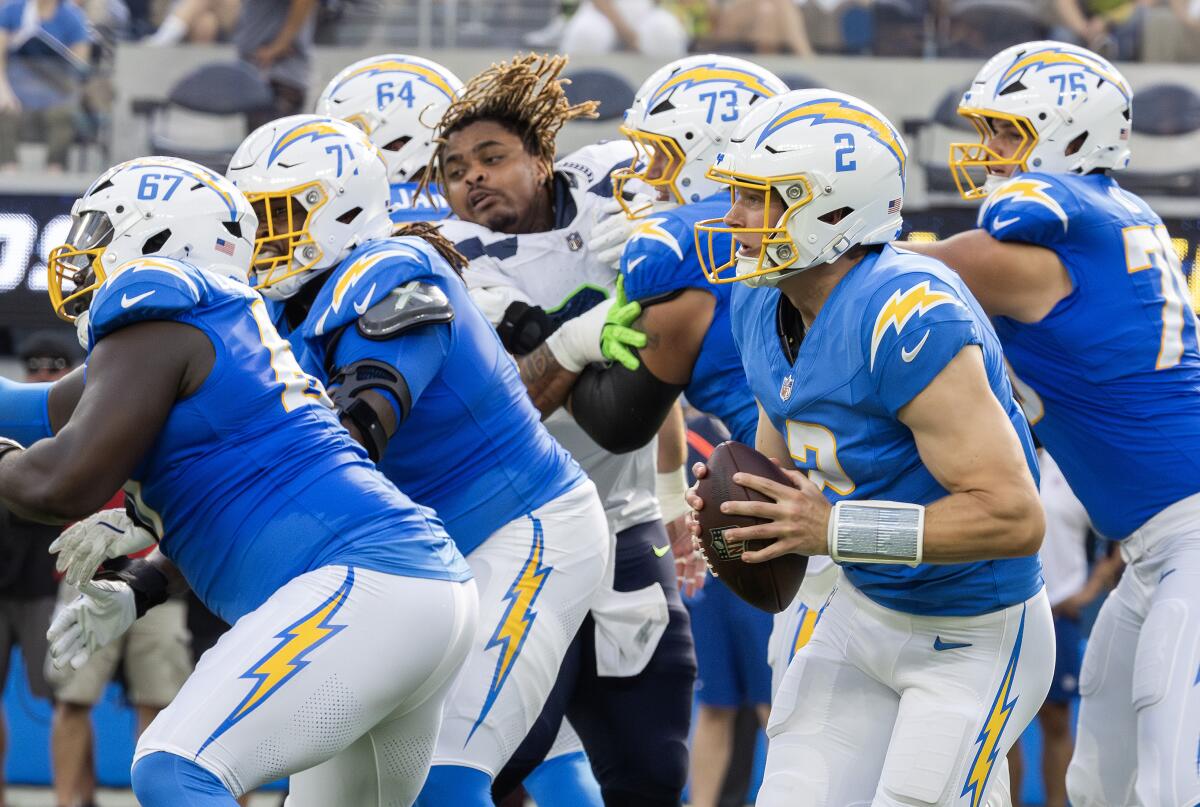 Chargers quarterback Easton Stick gets chased out of the pocket by the Seattle Seahawks during a preseason game. 