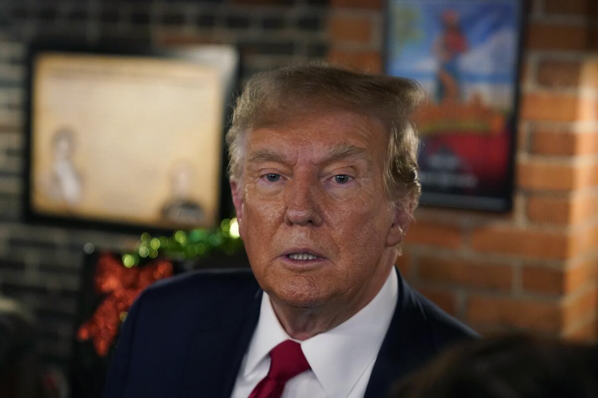 Former President Donald Trump talks to supporters during a stop at the Front Street Pub & Eatery, Tuesday, Dec. 5, 2023, in Davenport, Iowa. (AP Photo/Charlie Neibergall)