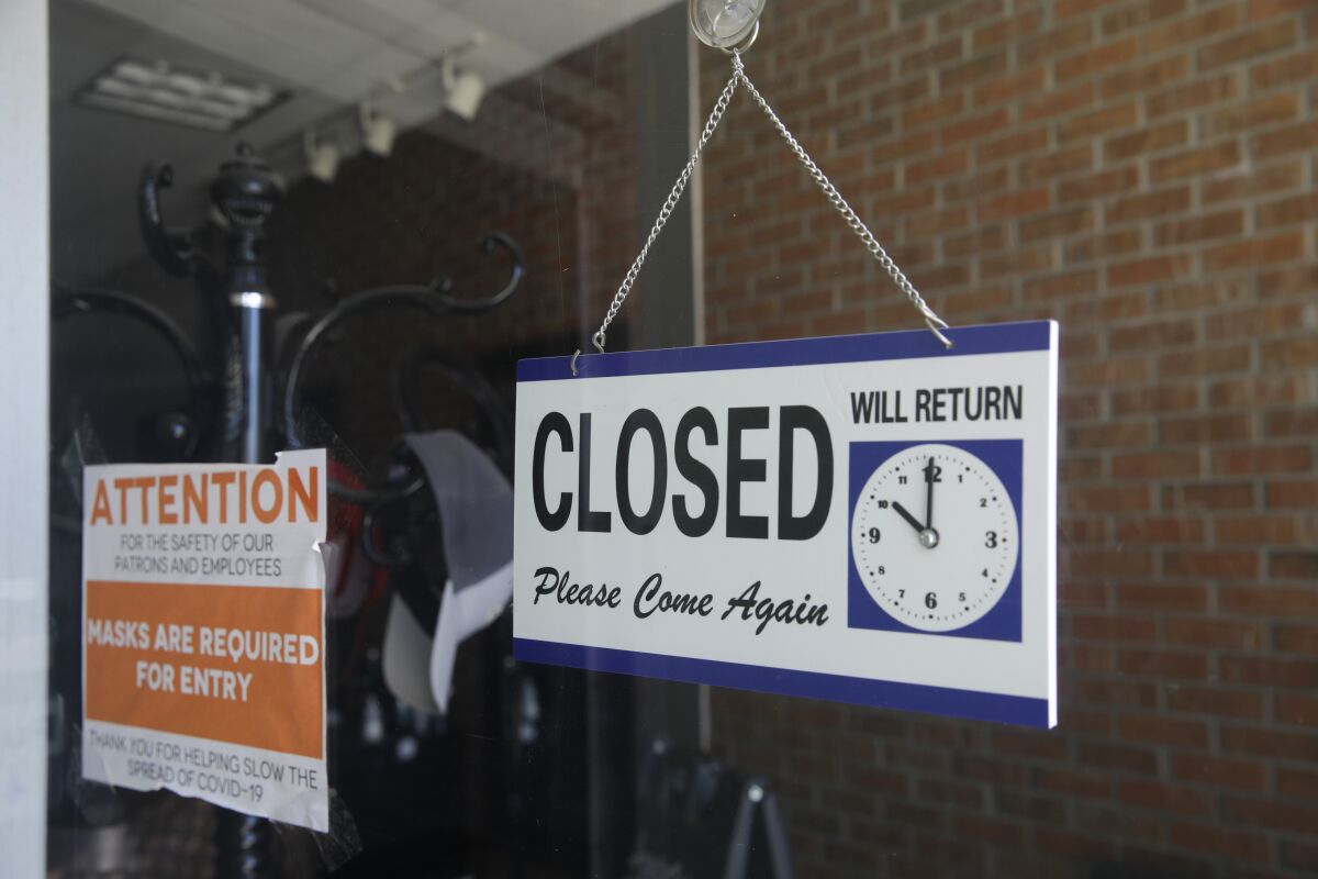 A closed sign hangs in a barbershop window in Burbank.