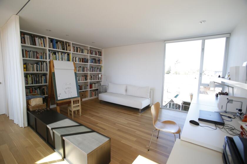 Built-in bookcases accommodate the couple's collections. The room acts as home office as well as drawing room for Jonah. The photo is taken from the glass wall facing the courtyard; another aluminum screen splashes the silhouette of poppies across the floor.