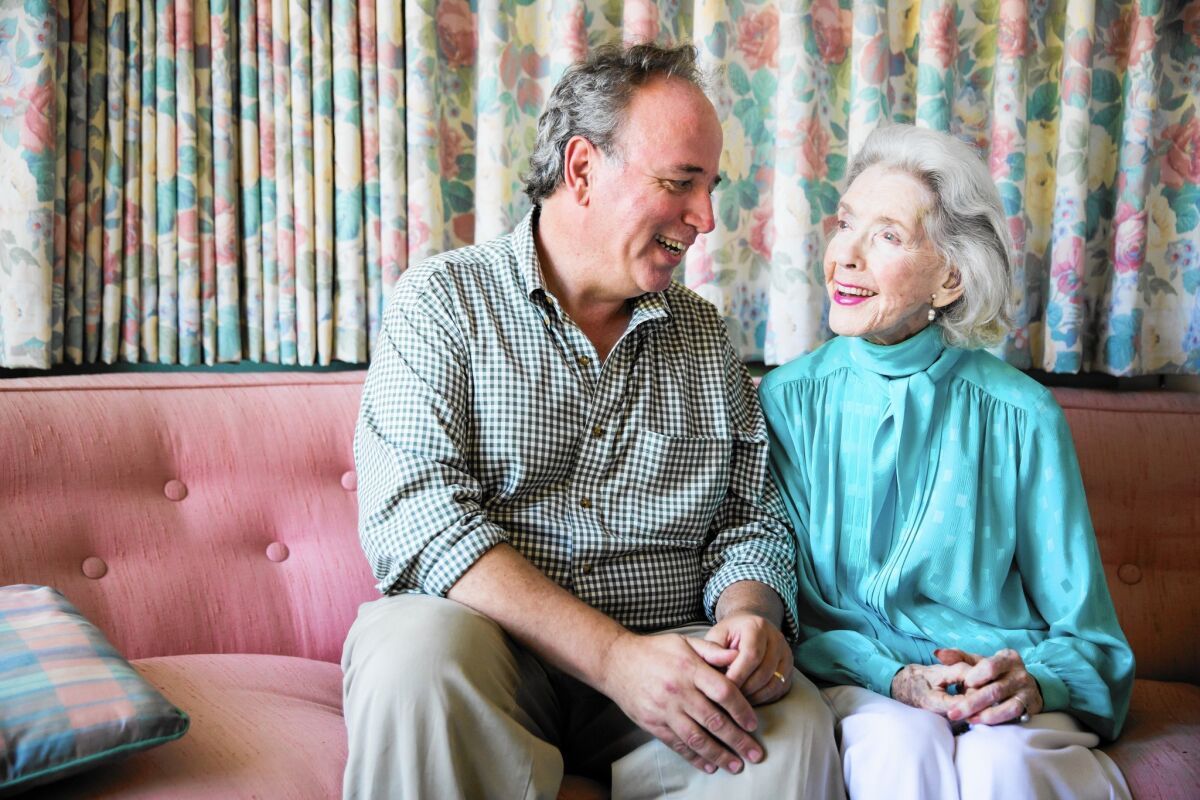 Marsha Hunt sits on a sofa with filmmaker Roger C. Memos.