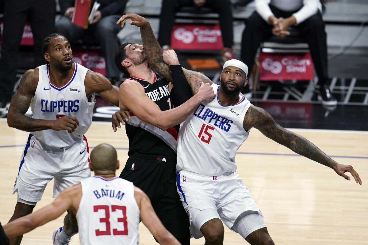 Clippers center DeMarcus Cousins works for position in the lane against rail Blazers center Enes Kanter.
