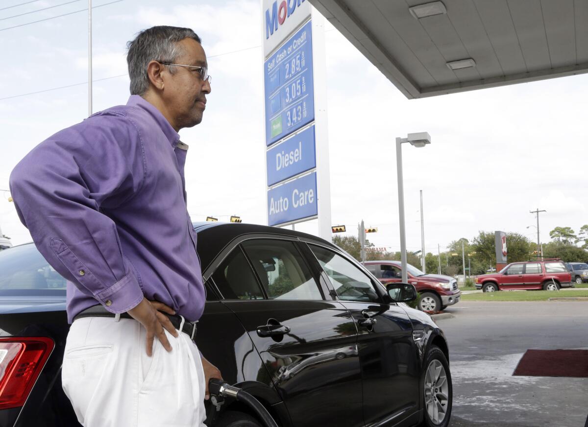 Mikel Marshall fills his car with gas at a Mobil station in Houston on Oct. 29.