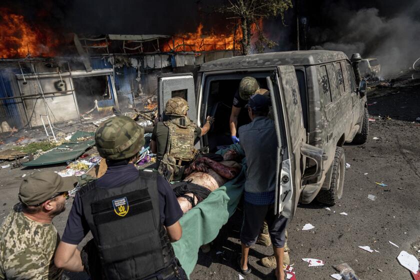 Paramedics carry an injured man into an ambulance after a Russian rocket attack on a food market in the city center of Kostiantynivka, Ukraine, Wednesday, Sept. 6, 2023. (AP Photo/Evgeniy Maloletka)