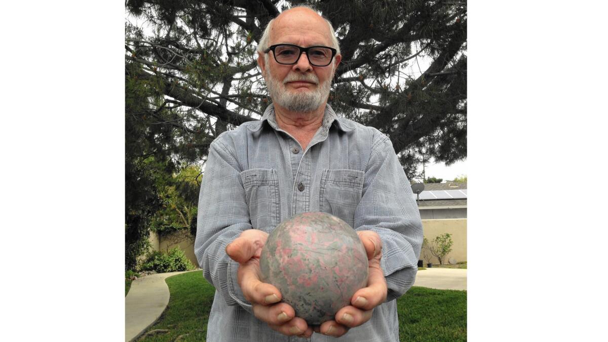 Jim Peterson, 82, of Santa Ana, holds a rock sphere he created with lapidary equipment. The rock was collected on what is now Mojave Trails National Monument.