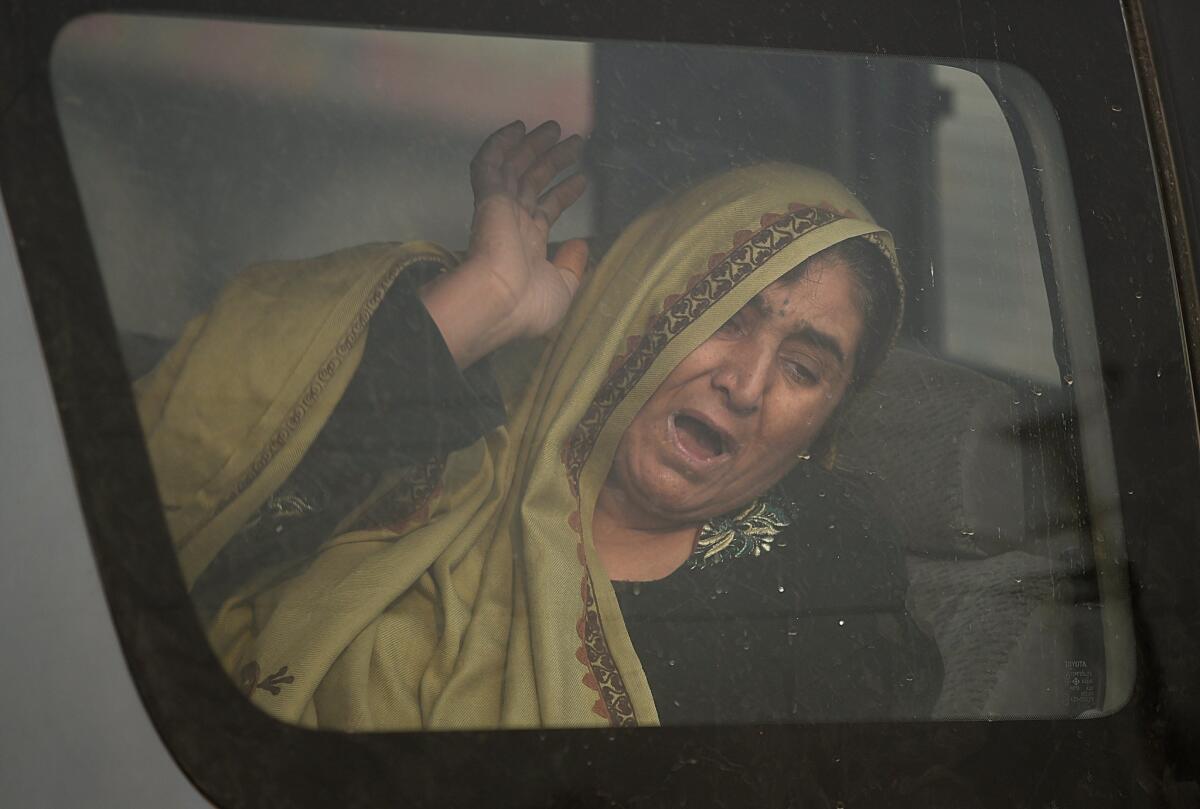 An Afghan woman inside a car reacts at the scene of a suicide attack on a European Union police vehicle along the Kabul-Jalalabad road in Kabul on Monday.
