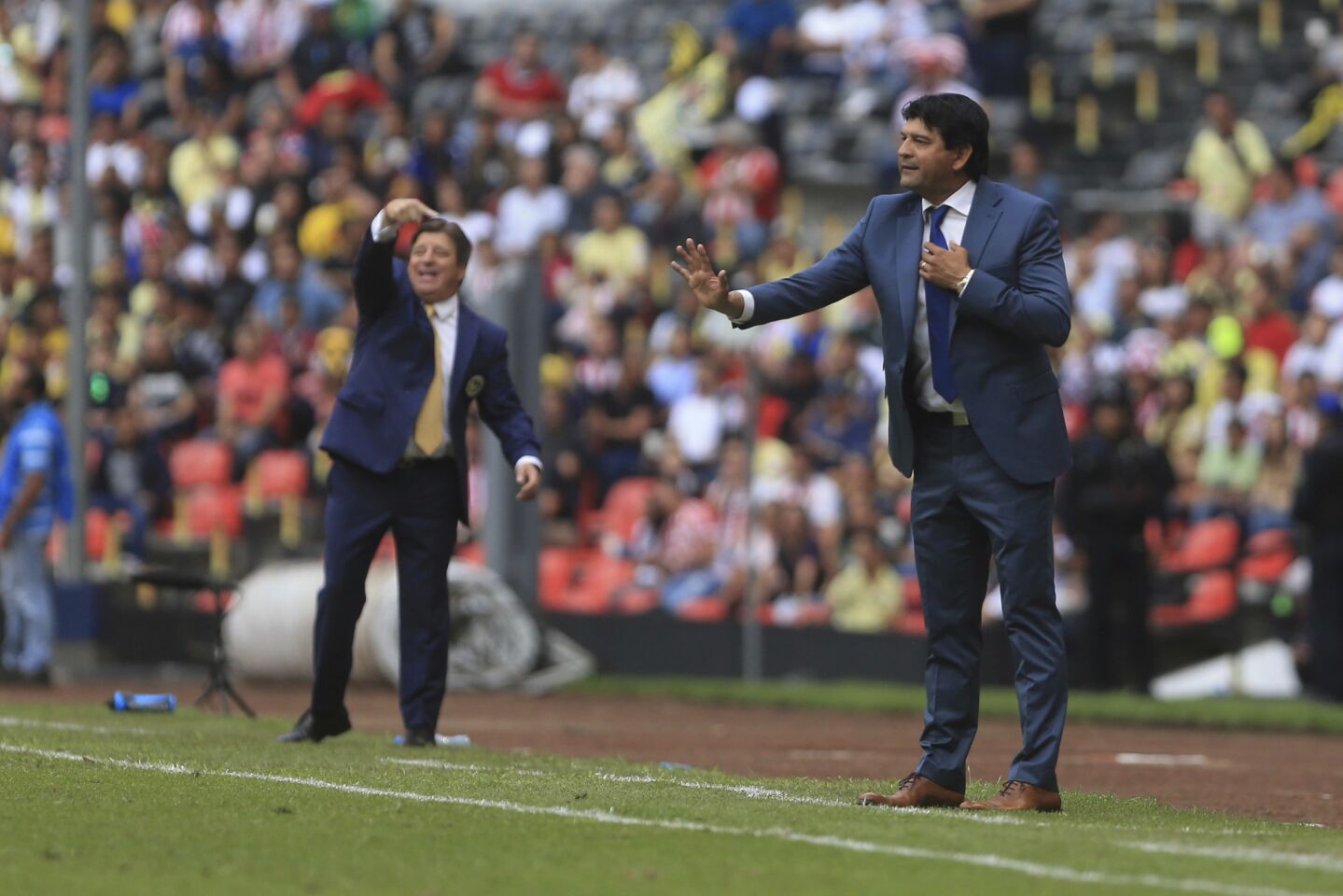 Chivas' head coach Jose Cardoso, right, gives indications to his players during a local soccer league match against America in Mexico City, Sunday, Sept. 30, 2018.