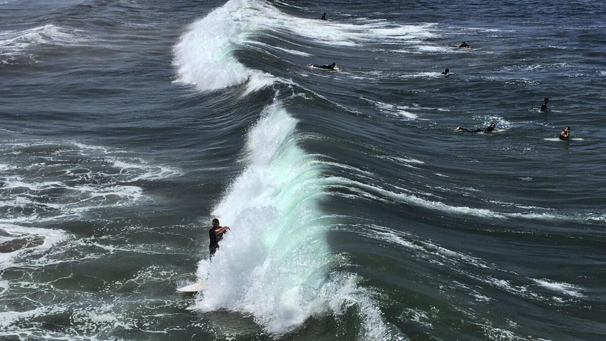 In Los Angeles, temperatures in the valleys could reach anywhere between 105 to 112 degrees, forecasters said. In this file photo a surfer catches a wave in Manhattan Beach, Calif.