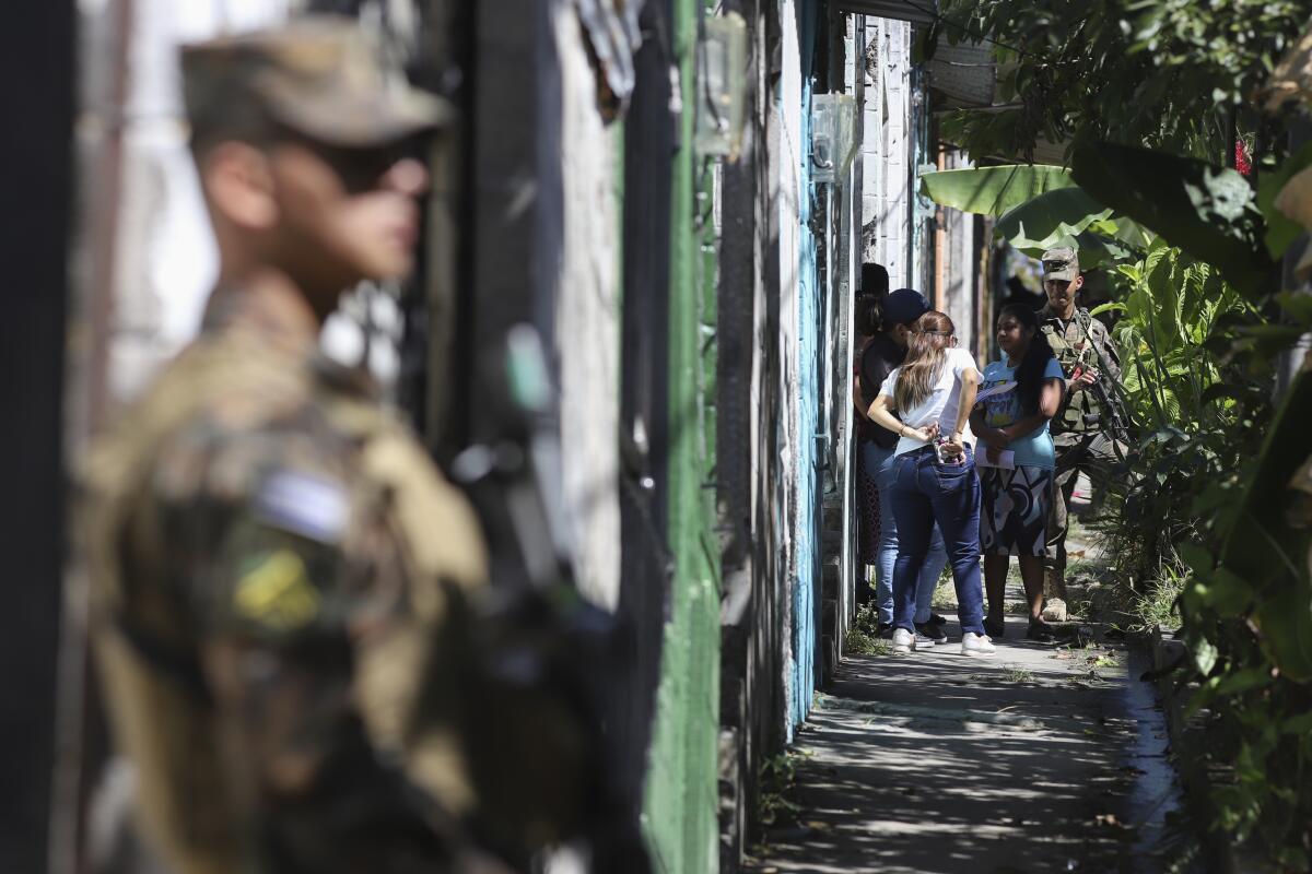 ARCHIVO - Militares salvadoreños patrullan por el barrio de La Campanera en Soyapango, 