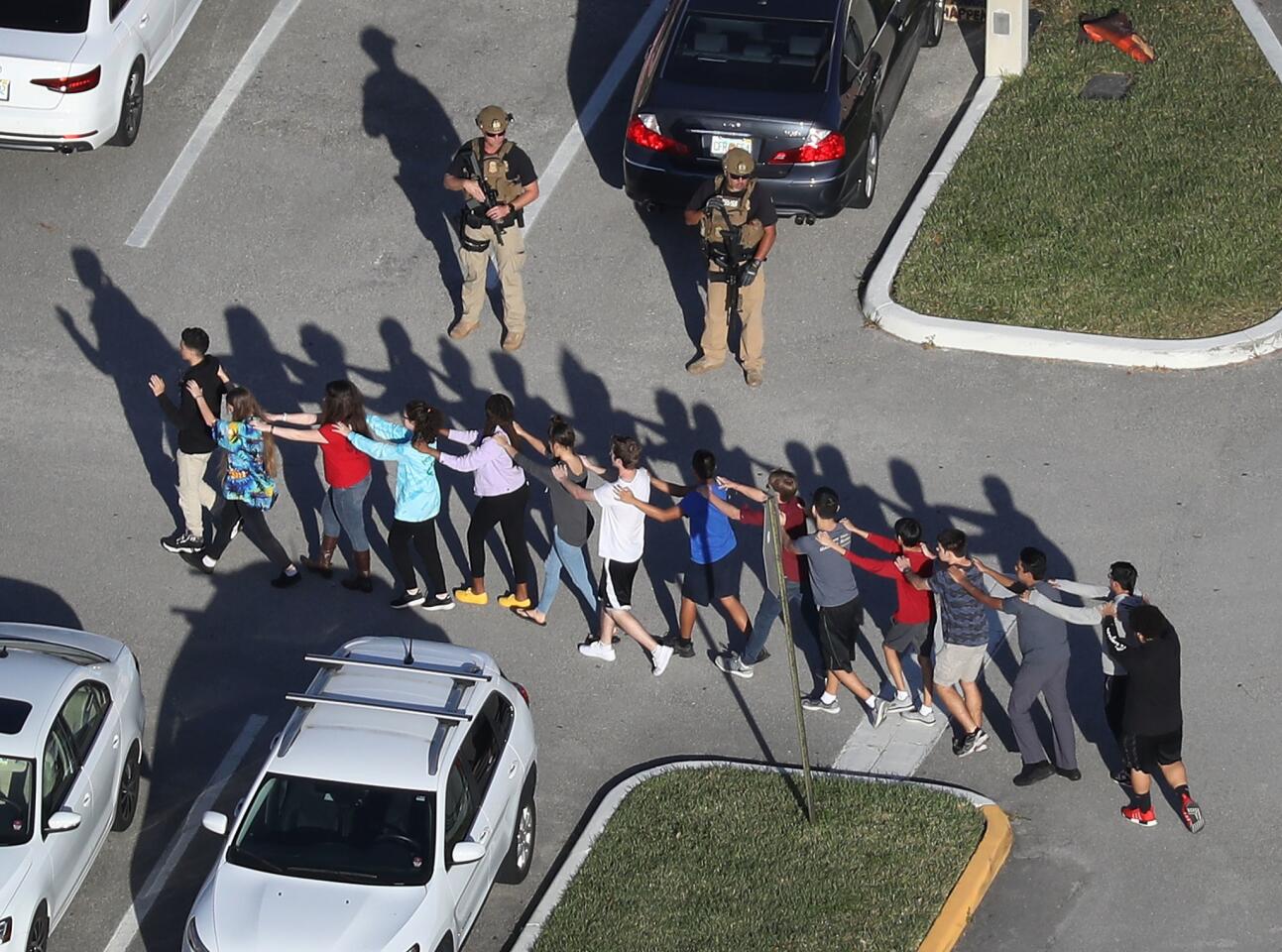 Students are brought out of the Marjory Stoneman Douglas High School after a shooting at the school that killed 17 people on Feb. 14, 2018 in Parkland, Fla.