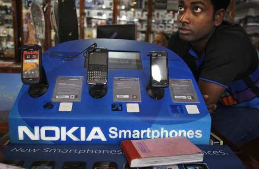 An Indian shopkeeper selling Nokia mobile phones awaits customers in New Delhi. Moody's cut Nokia's rating to junk on Friday