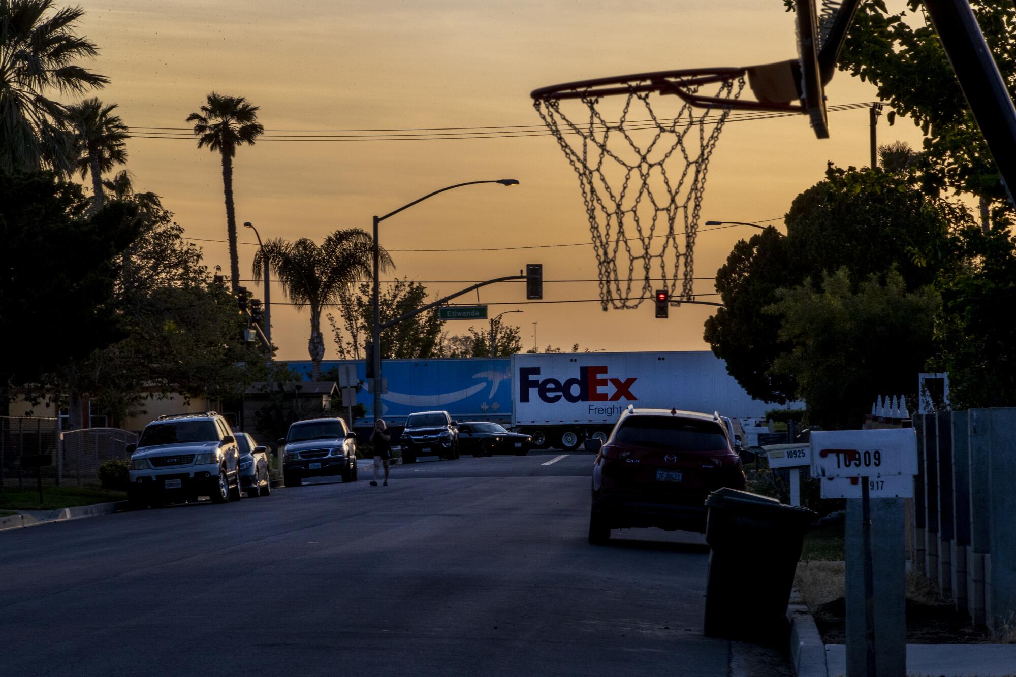 A big rig trucks pass by a neighborhood.