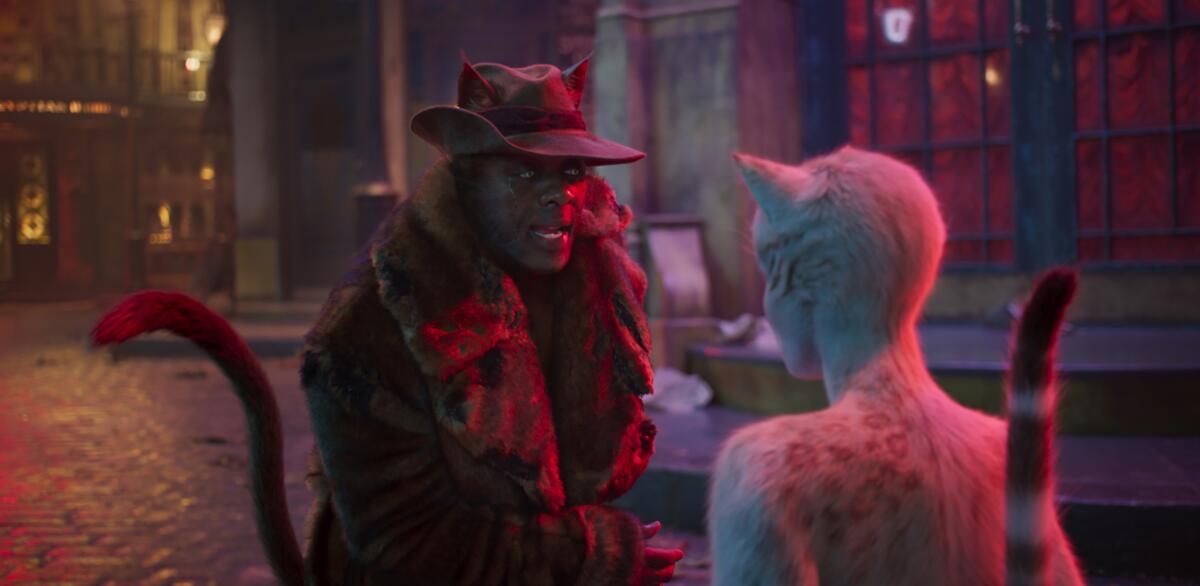Idris Elba as Macavity, left, and Francesca Hayward as Victoria in a scene from "Cats."
