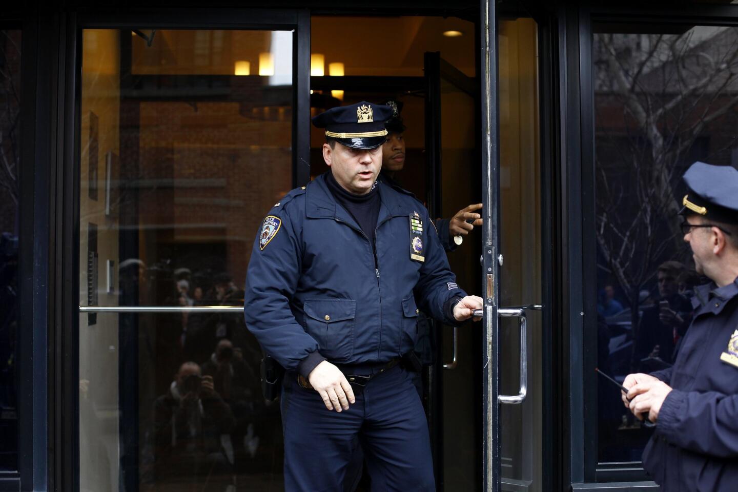 Police officers stand outside Philip Seymour Hoffman's apartment