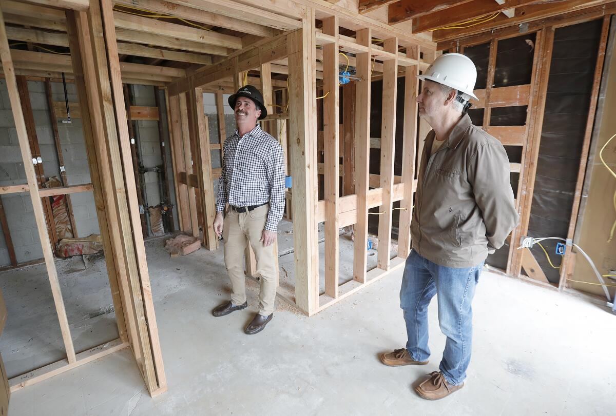 CDP President Kyle Paine and Mercy House CEO Larry Haynes, from left, stand Thursday at an old Motel 6 on Newport Boulevard.