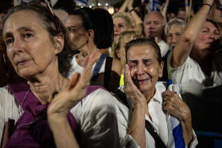 A woman reacts while listening to speeches by family members of hostages still held by Hamas during a solidarity protest