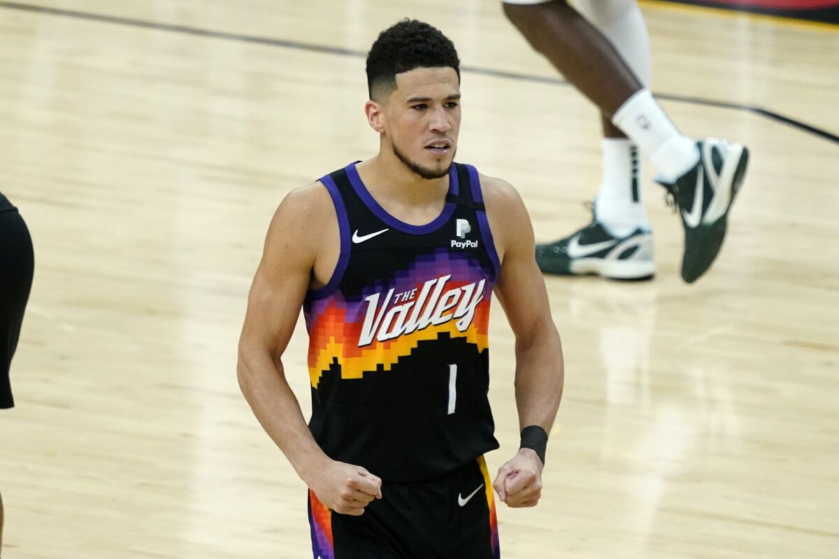 Phoenix Suns guard Devin Booker pumps his fists after a basket against the Milwaukee Bucks.