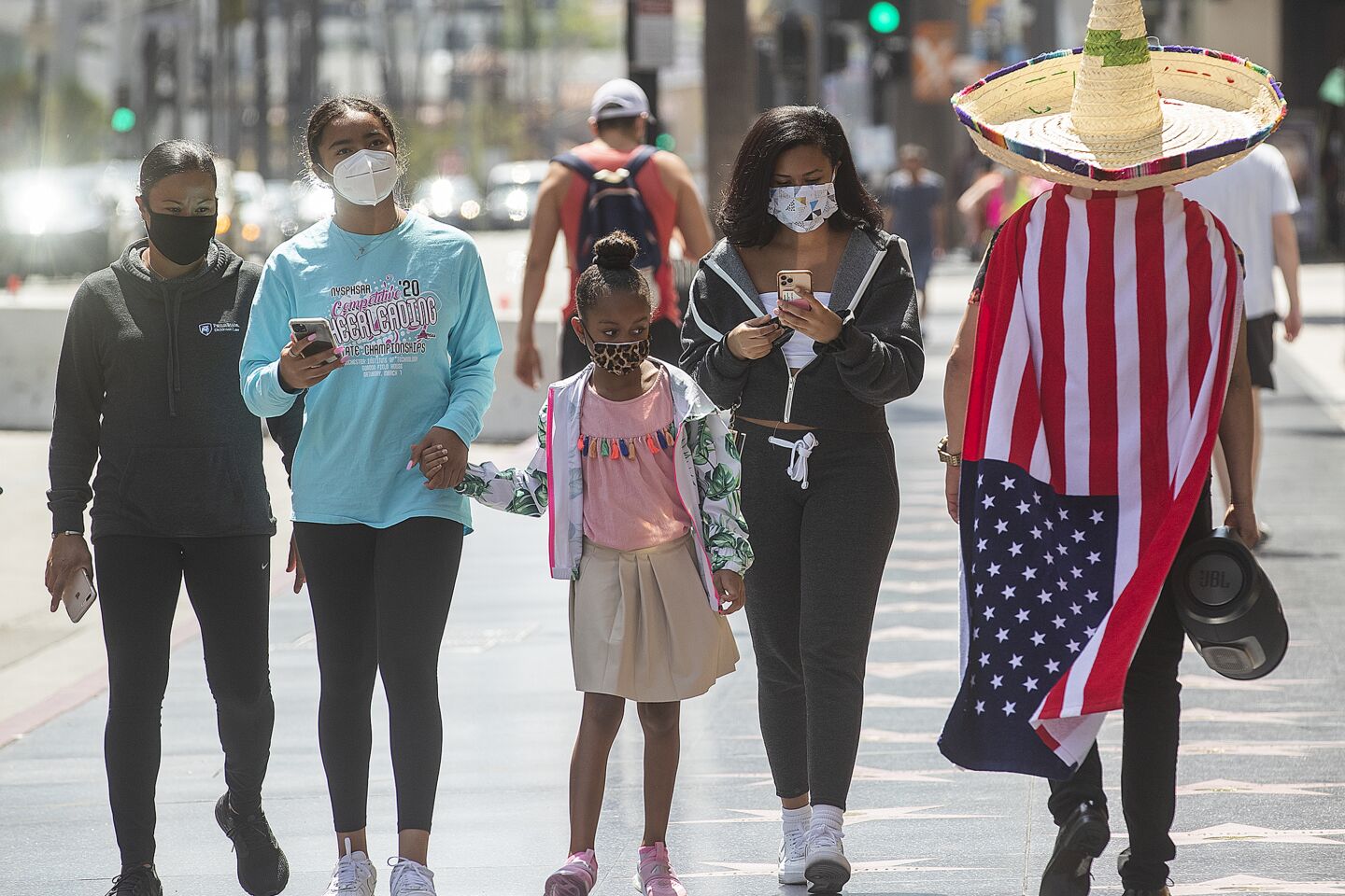 Jair Guido, right, walks with other pedestrians along Hollywood Boulevard in Hollywood.
