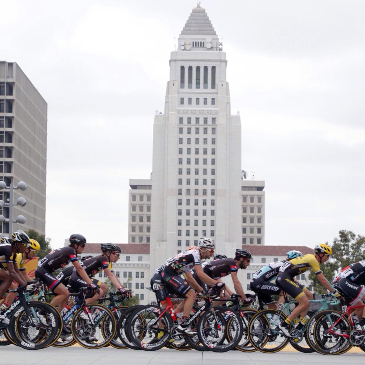 Bicyclists race past Los Angeles City Hall.