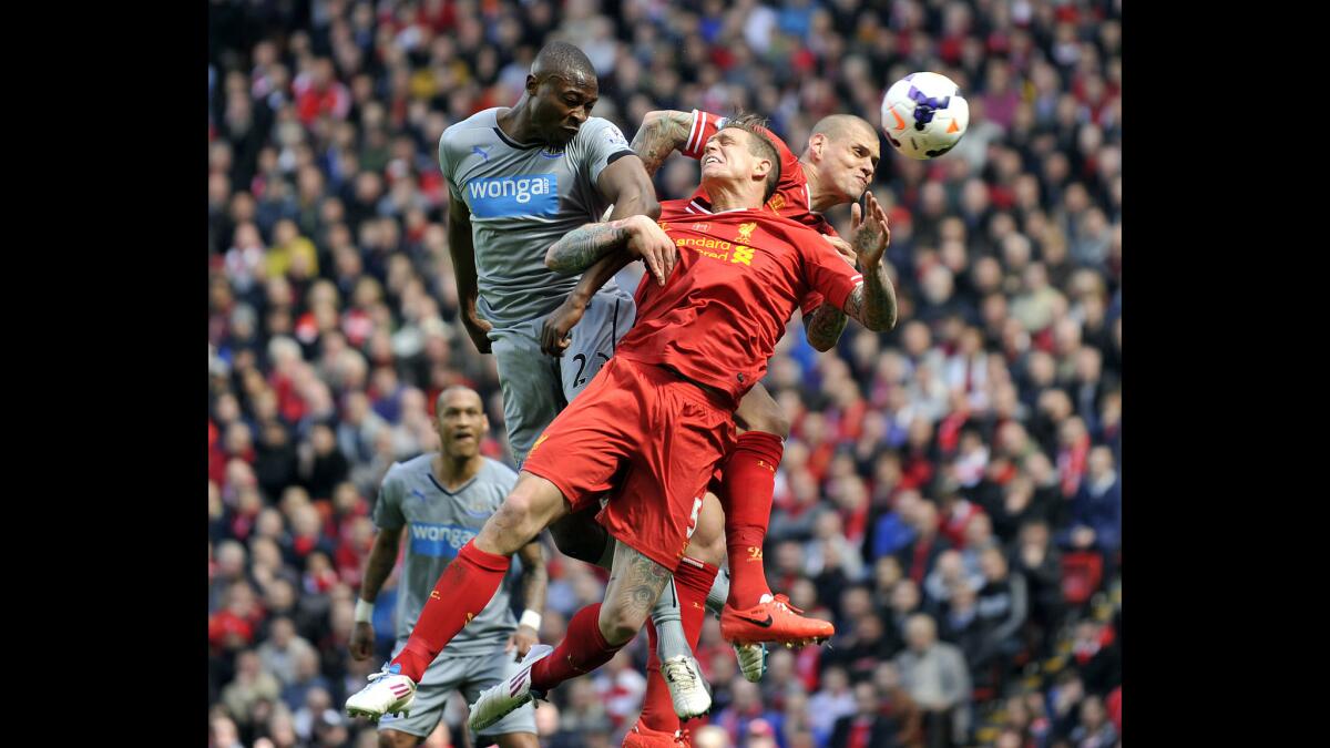 Liverpool's Daniel Agger, center, and Martin Skrtel, right, jump for the ball with Newcastle United's Shola Ameobi during an English Premier League match at Anfield. The Liverpool Football Club offers six tours of Anfield Stadium.