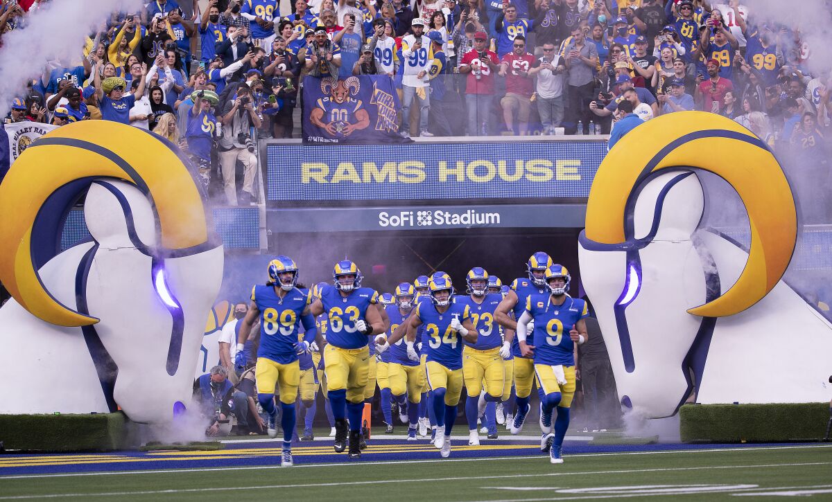 Fans cheer as Rams quarterback Matthew Stafford (9) leads the team onto the field.