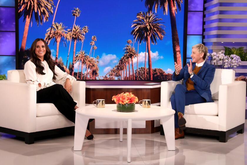 Two women sitting in armchairs on stage