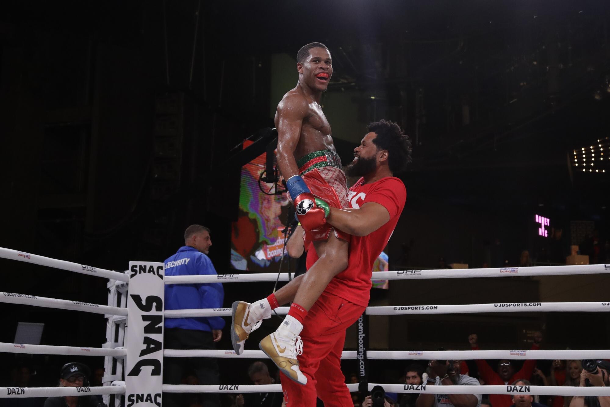 Bill Haney hoists up his son, Devin Haney, while celebrating Devin's win over Russia's Zaur Abdullaev in 2019