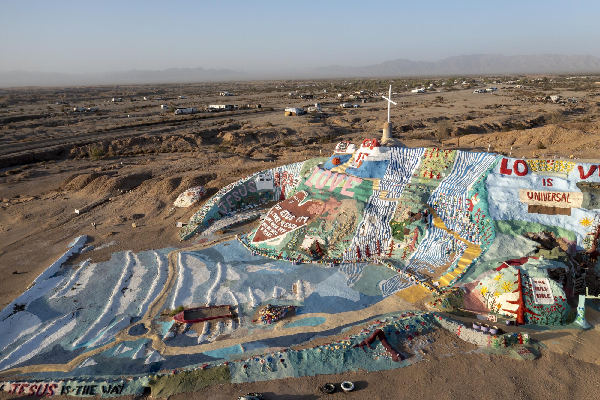 An aerial view of Salvation Mountain, a colorful hillside Christian monument in Slab City 