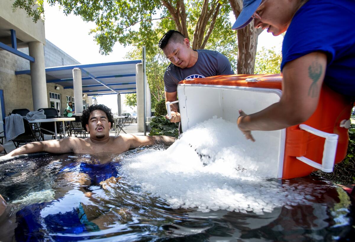 Jairus Satele cools down in an ice tub after a hot practice with the San Jose State football team, Tuesday, Aug. 16, 2022, in San Jose, Calif. Forecasts for more scorching heat and monsoon moisture brought calls for Californians to conserve electricity Wednesday, Aug. 17, 2022, and warnings that lightning, thunderstorm winds and parched vegetation were a recipe for wildfires. (Karl Mondon/Bay Area News Group via AP)