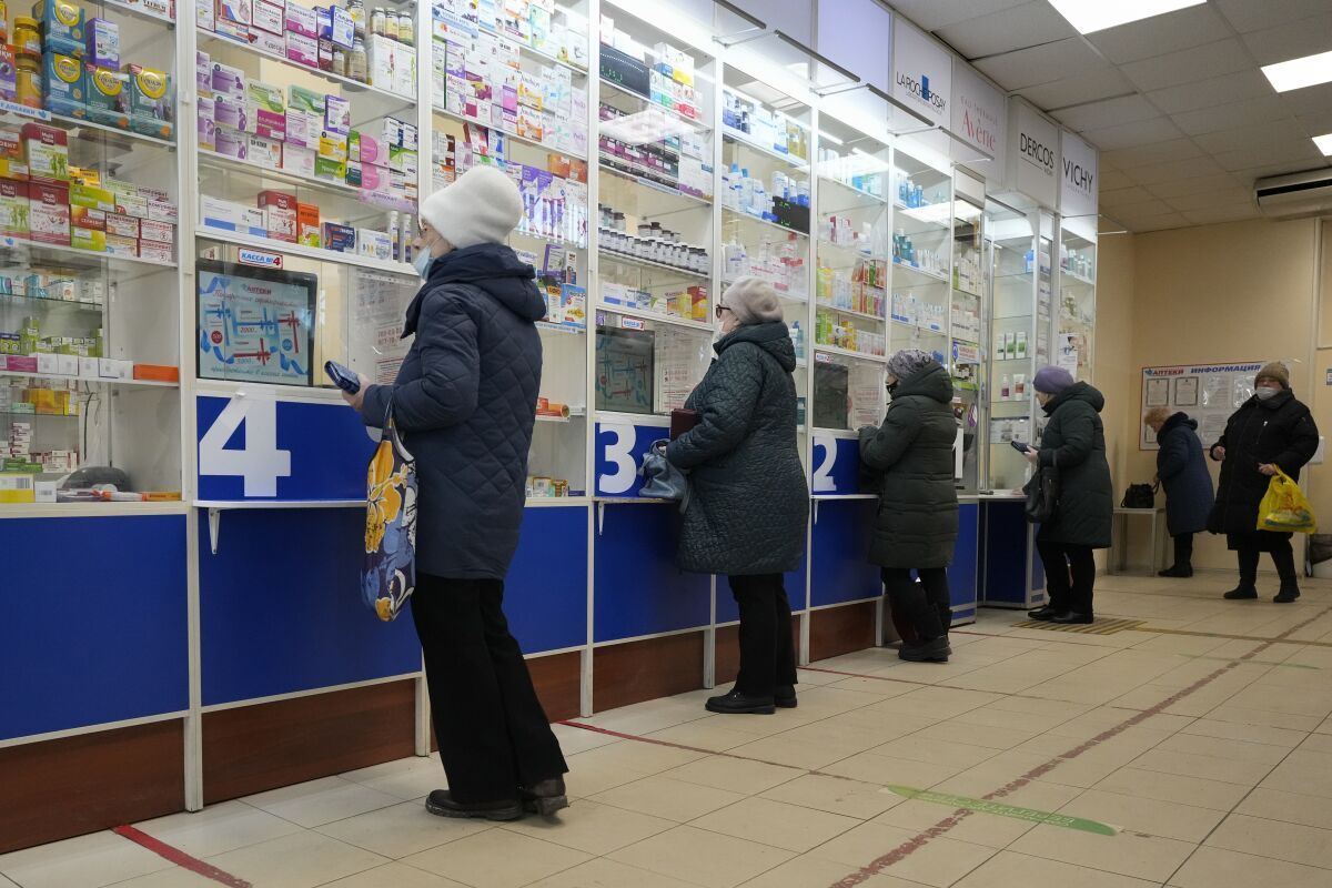 Customers stand at the windows buying medicines in a pharmacy in St. Petersburg, Russia, Friday, April 1, 2022. (AP Photo)