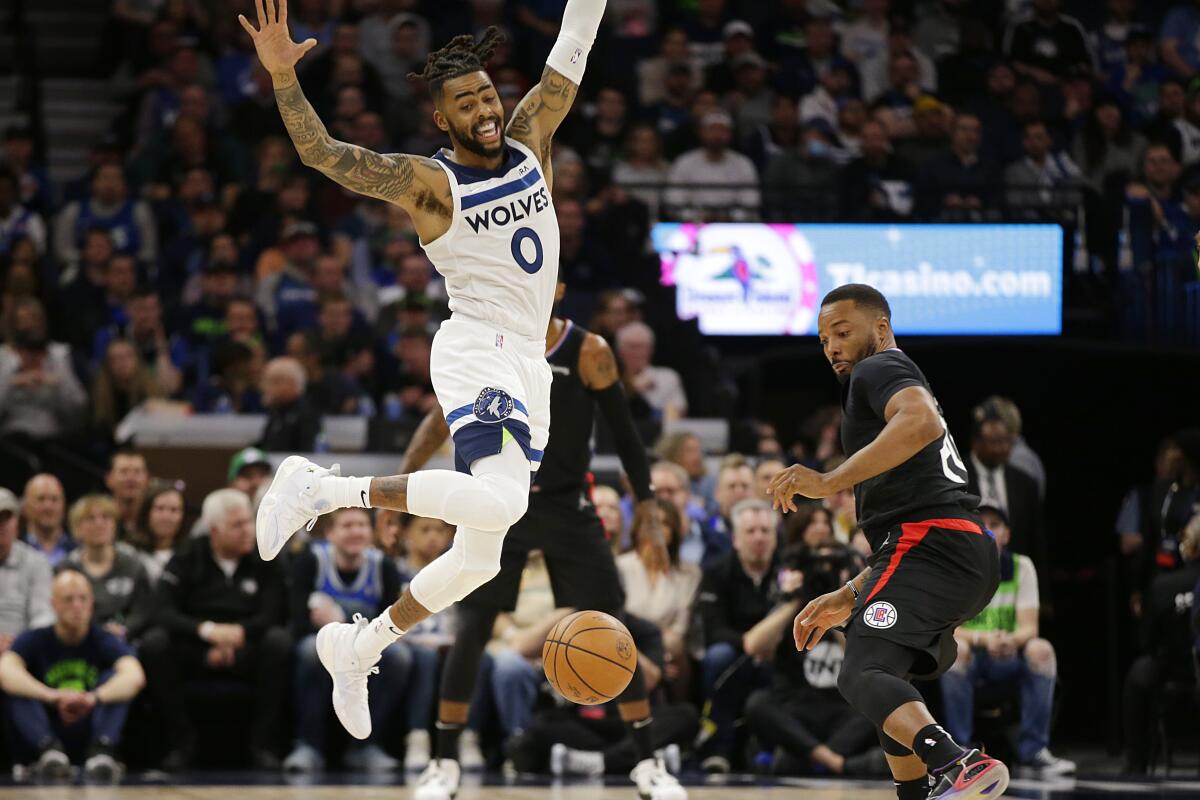 Timberwolves guard D'Angelo Russell, left, loses control of the ball while Clippers forward Norman Powell looks on.