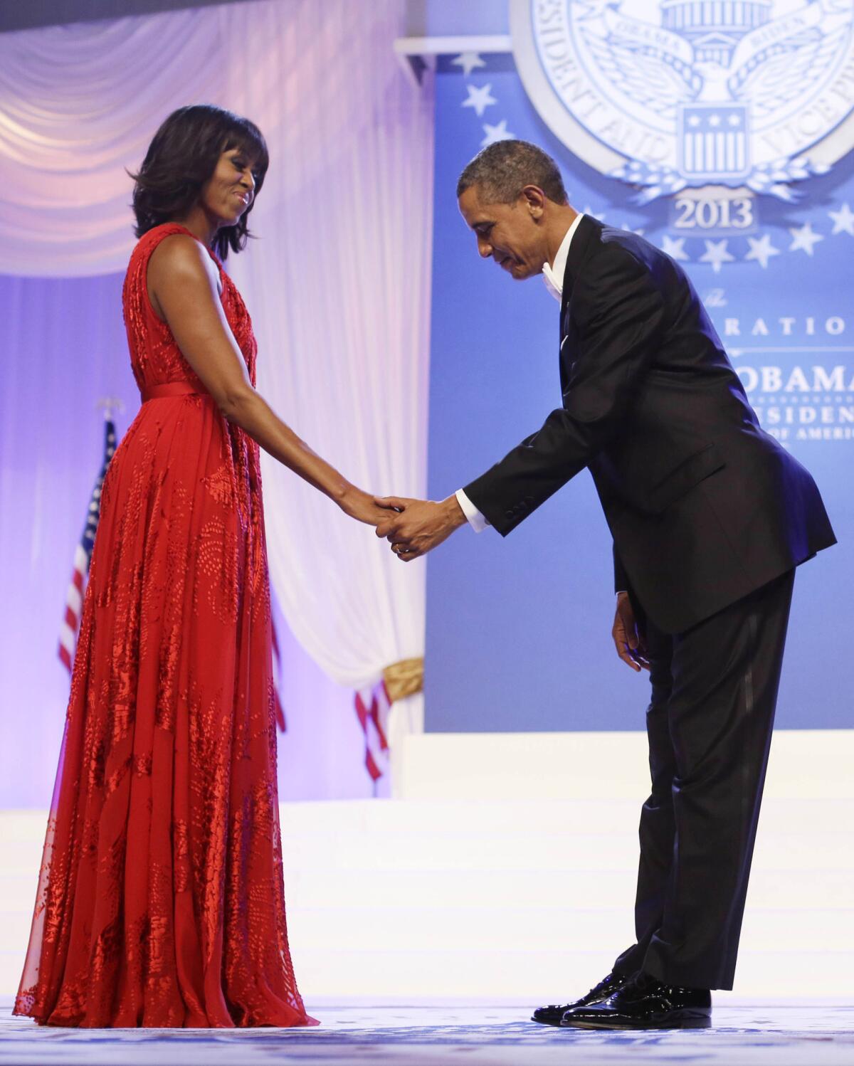 At a ball celebrating his second inauguration, President Obama bows to Michelle Obama, who is wearing the Jason Wu gown that is to be displayed at the Smithsonian Institution.