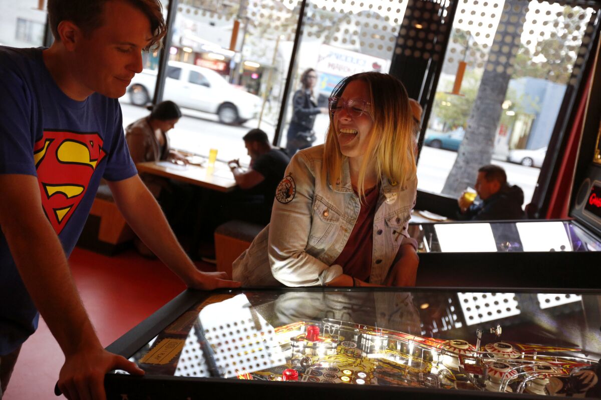 Mason Hankins, 26, and Roxy Lange, 30, play pinball on a date at Button Mash, a restaurant on Sunset Blvd.