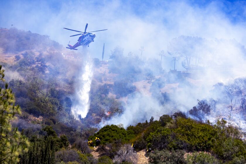 LOS ANGELES, CA - JULY 30: Los Angeles City fire helicopter drop water on a brushfire in mostly inaccessible terrain in the Hollywood Hills on Thursday, July 30, 2020 in Los Angeles, CA. (Brian van der Brug / Los Angeles Times)
