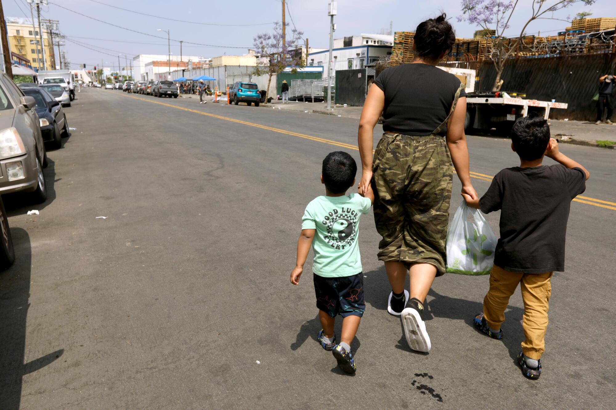 A mother walks with her children along Towne Avenue where many homeless