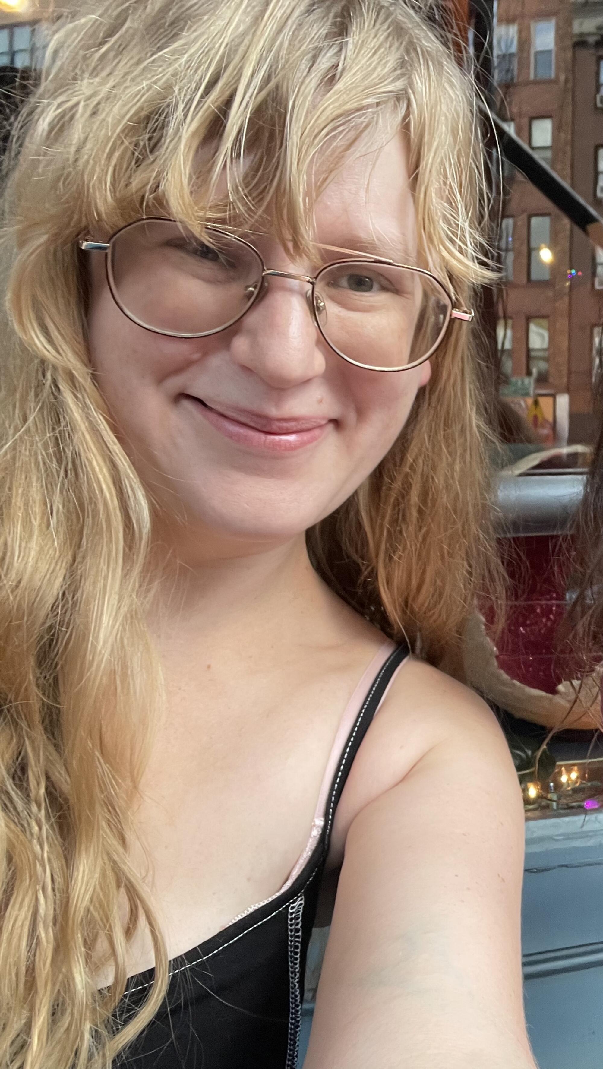 A selfie of a blond woman with glasses.