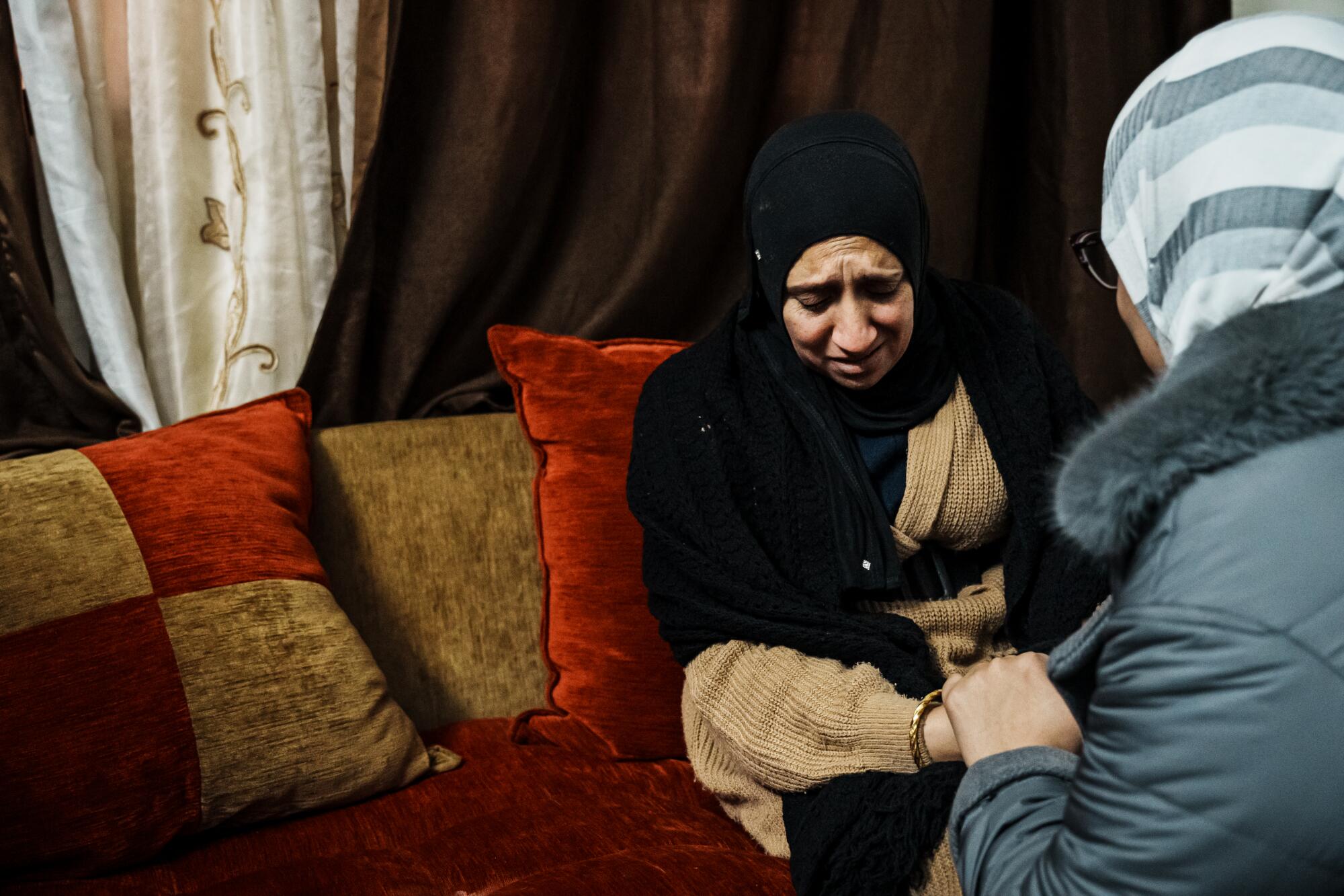 A woman is comforted as she mourns the death of her two children.