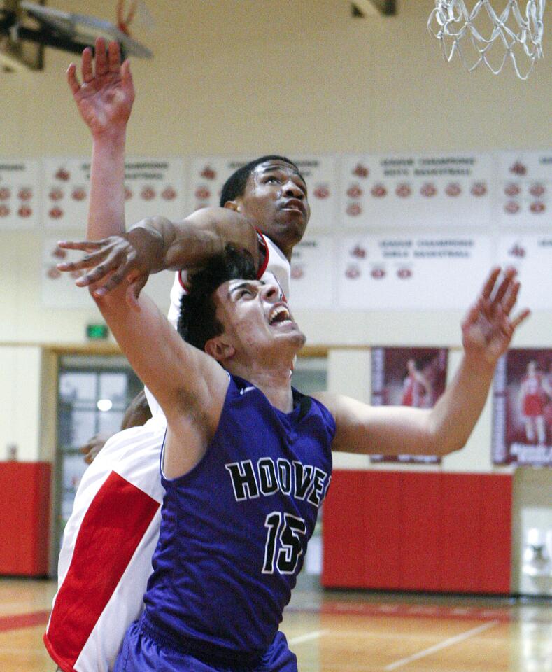 Hoover's Tadeh Essagholian is fouled while taking a shot by Burroughs' Amaad Wainright in a Pacific League boys basketball game at Burroughs High School in Burbank on Tuesday, January 28, 2014. (Tim Berger/Staff Photographer)