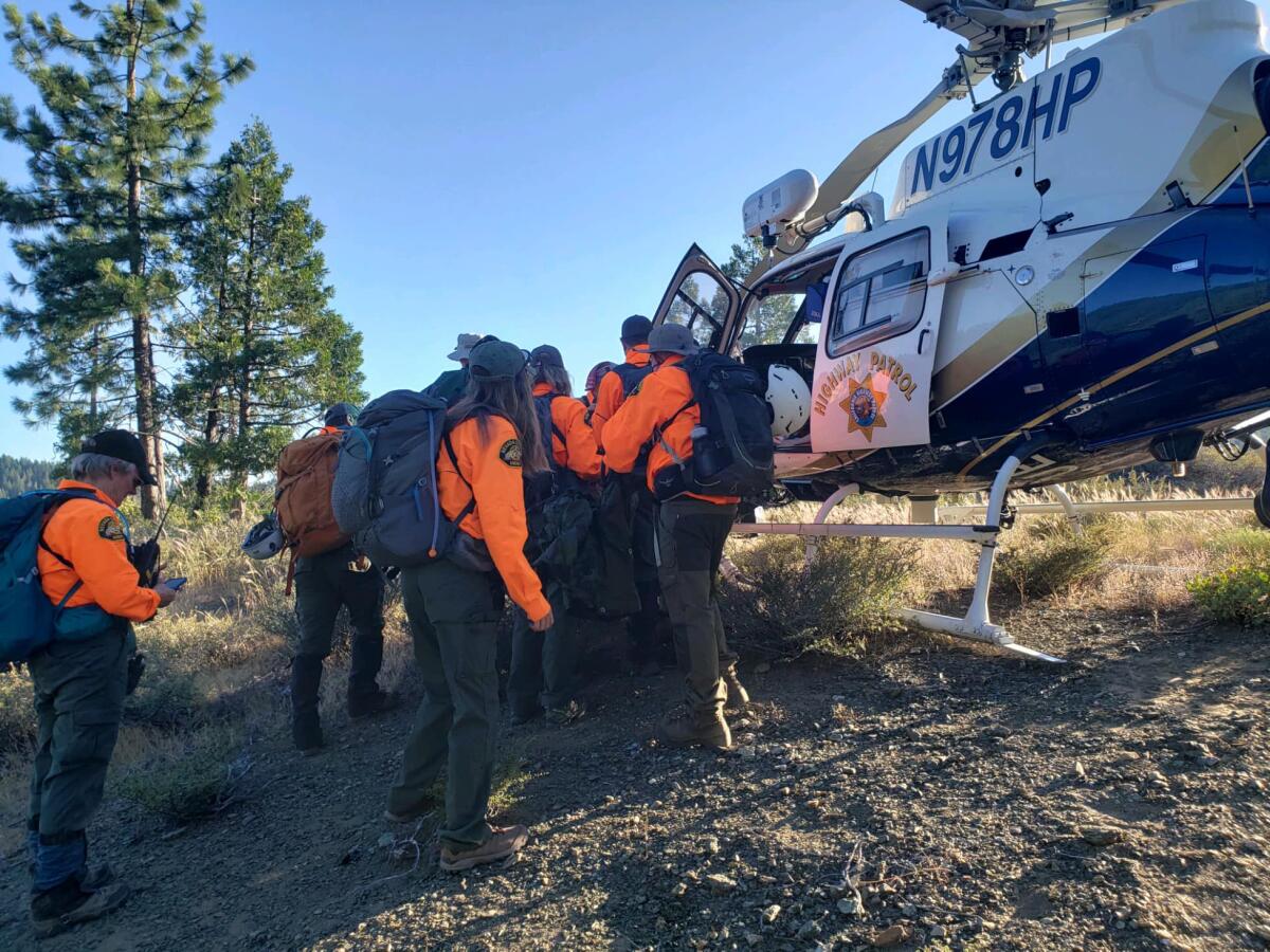 Search and rescue team members put an injured man in a helicopter. 