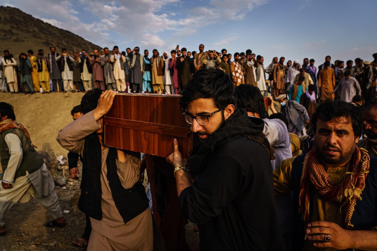 Caskets of the dead are carried at a mass funeral for civilians killed in a U.S. drone strike in August.