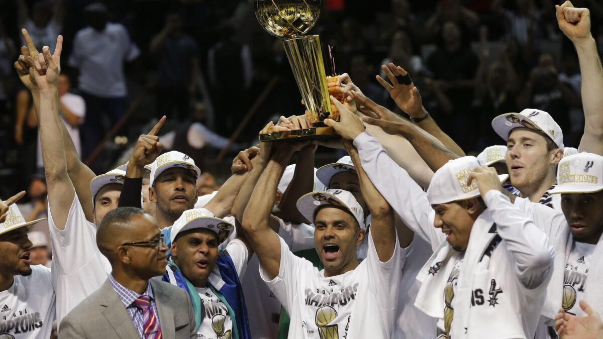 San Antonio Spurs guard Tony Parker lifts the Larry O'Brien Trophy after Game 5 of the 2014 NBA Finals.