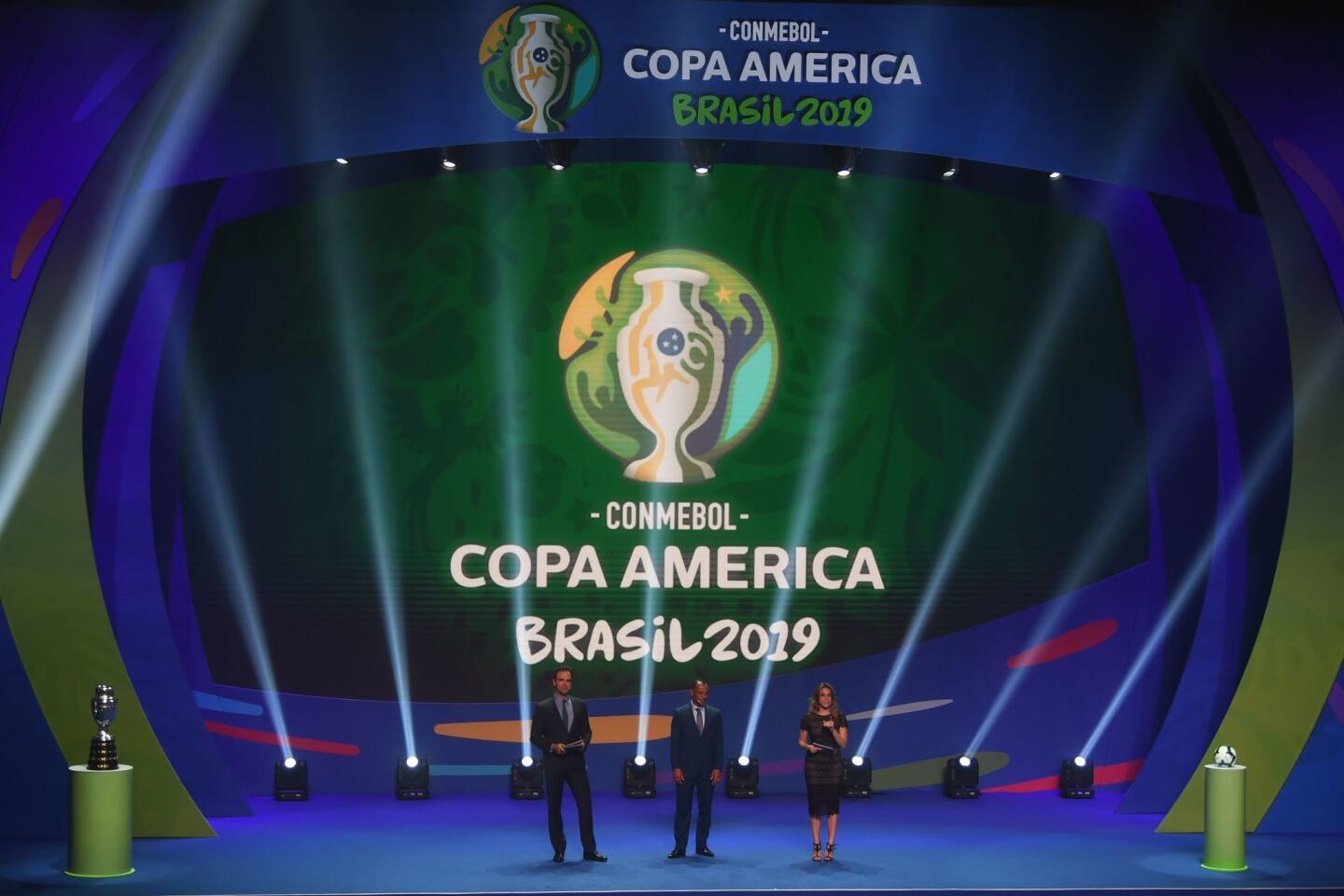 TV presenters Tadeu Schmidt (L) and Fernanda Gentili (R) and Brazilian former footballer Cafu present the draw of the 2019 Copa America football tournament, in Rio de Janeiro, Brazil, on January 24, 2019. - The 2019 Copa America will be held in Brazil between June 14 and July 7.